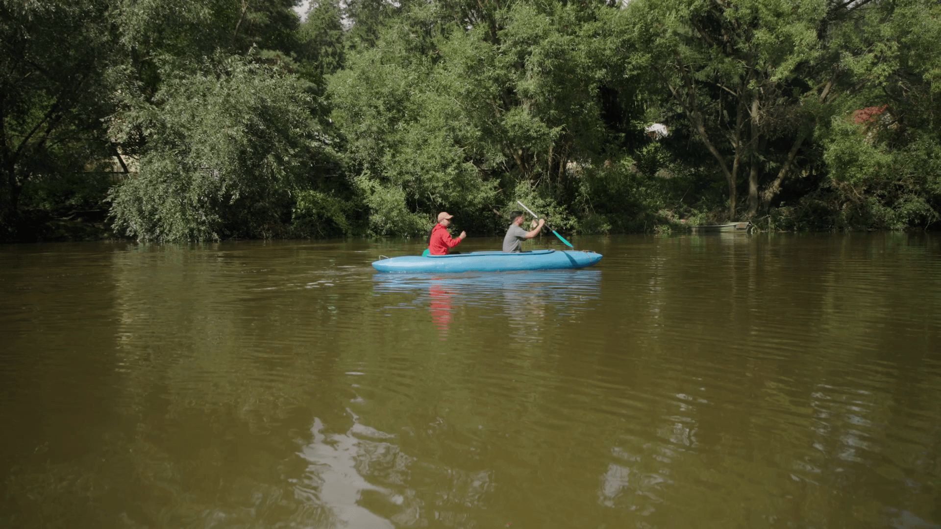 Two colleagues paddling a canoe on the river
