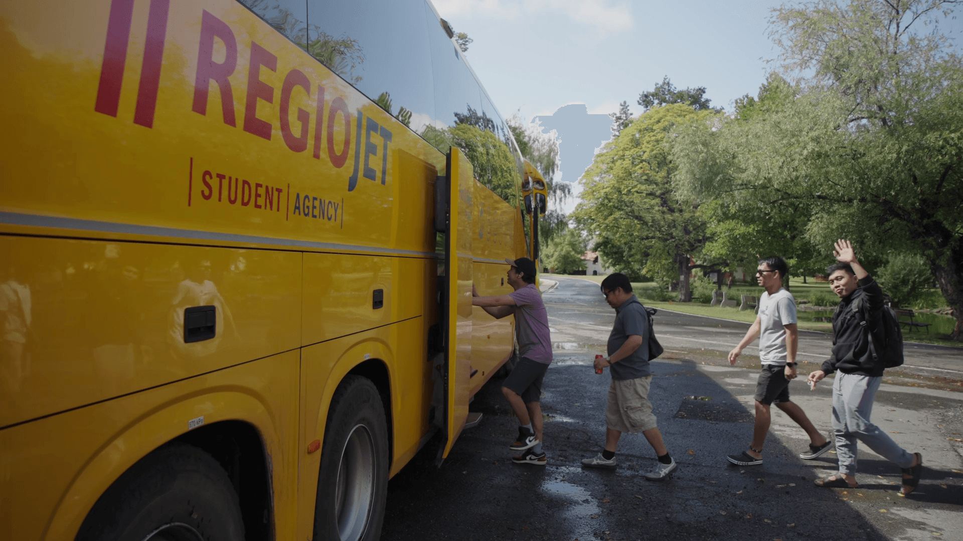 Colleagues boarding a yellow RegioJet coach for a weekend trip